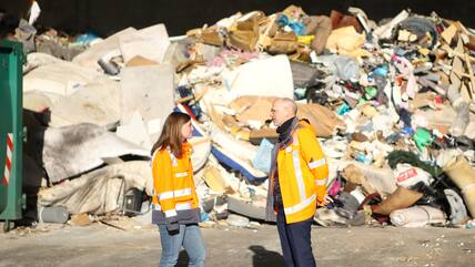 BAWN-Vorstand Arne Henrik Meyer im Gespräch mit Unternehmenssprecherin Johanna Müller vor einem Berg aus Sperrmüll.